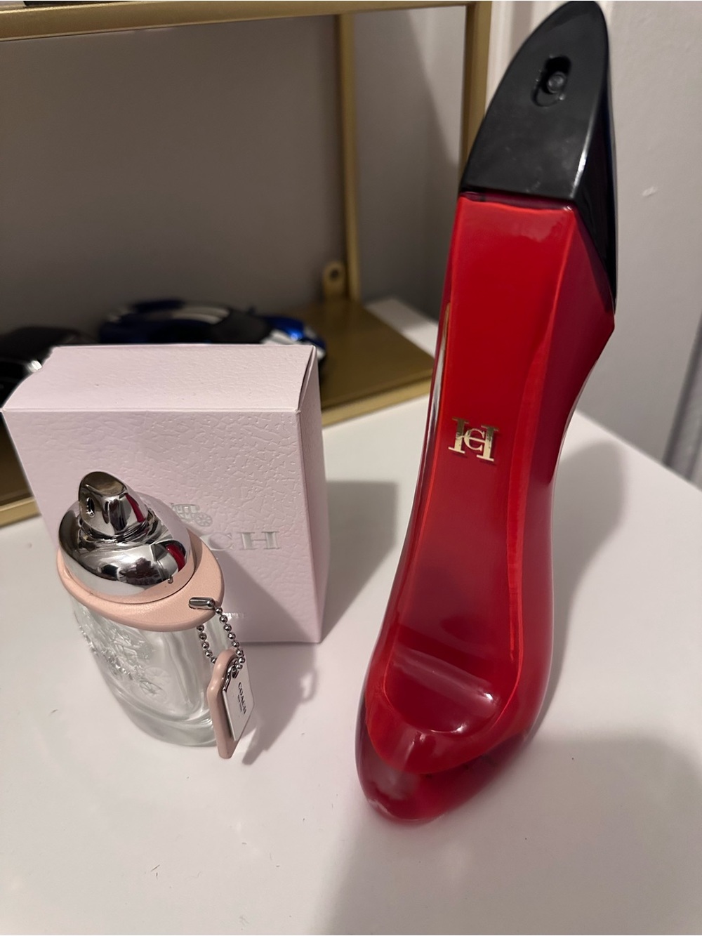 Empty Carolina Herrera Red and Black Stiletto and Coach Bottles